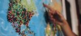 A world map with many pins stuck in it